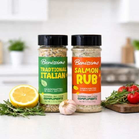 Two jars of Benissimo seasoning on a kitchen counter with herbs and lemon.