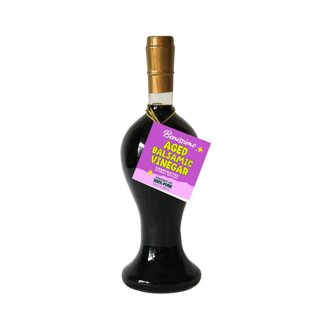 Bottle of aged balsamic vinegar with a purple label on a white background
