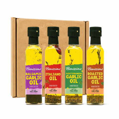 Four bottles of Benissimo oil with colorful labels in front of a cardboard box.