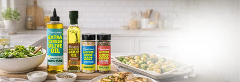 Assorted cooking oils and seasonings on a kitchen counter with food in the background